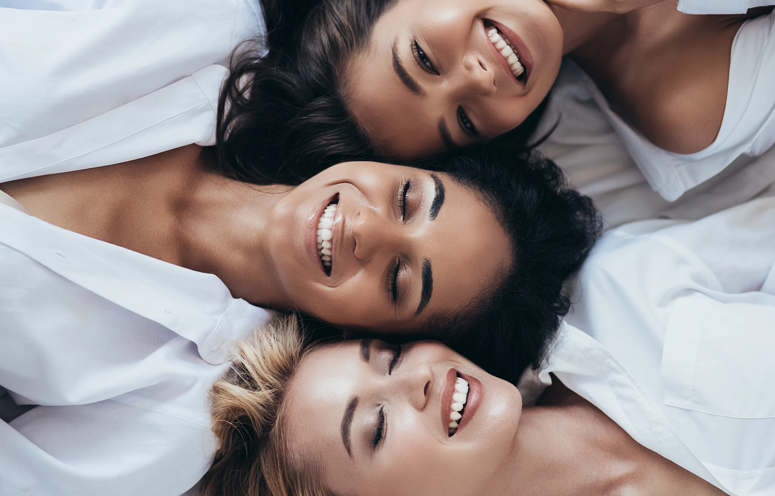 A group of three women laying next to each other.