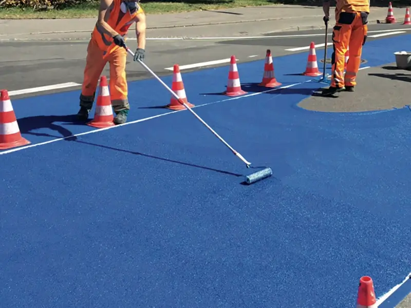 Applicators rolling on colorful pavement coatings