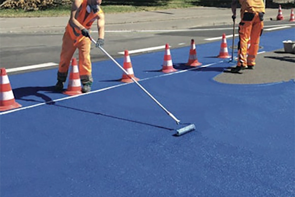 Applicators rolling on colorful pavement coatings