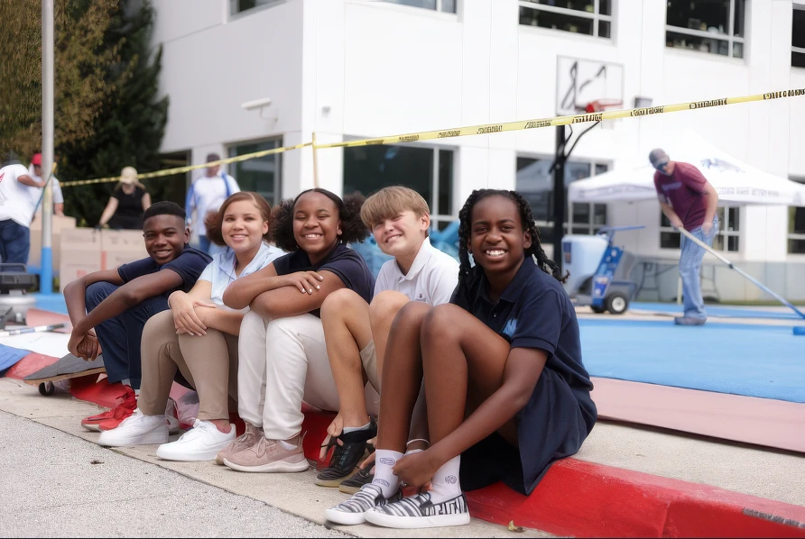 Community children sitting by and watching StreetBond being installed on their playground.
