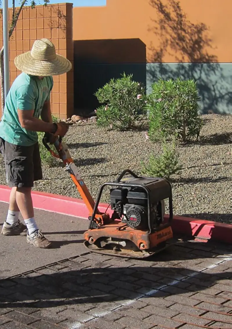 Contractor stamping asphalt with a heater