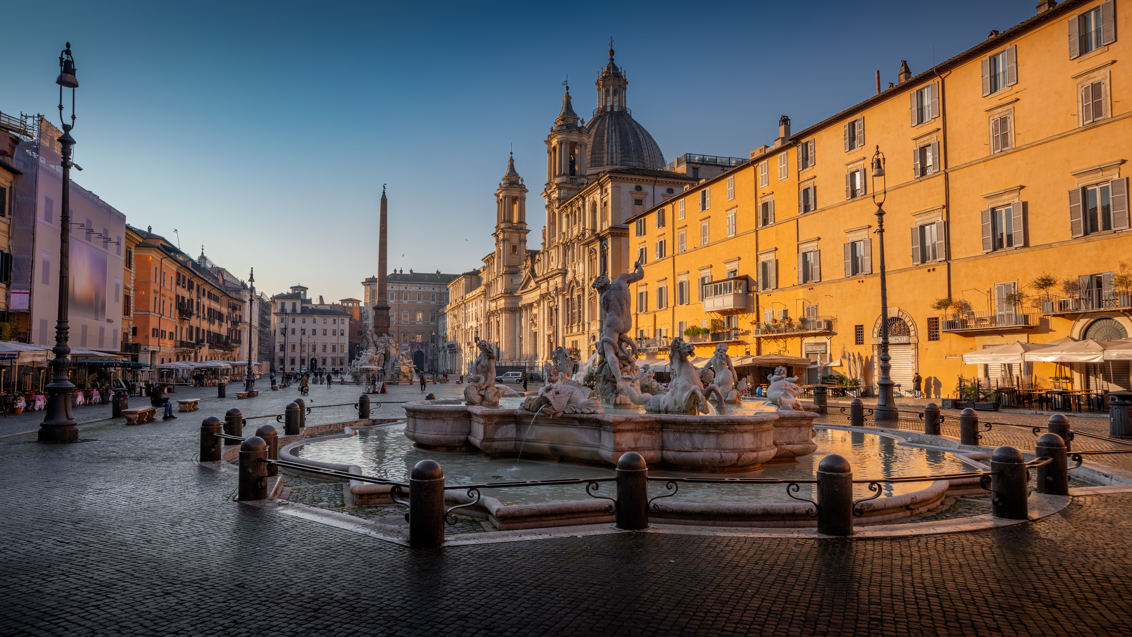 Student works at a computer and looks toward 3d printer.