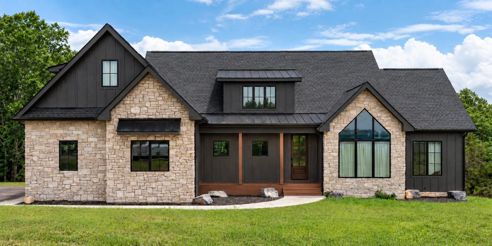 Finished custom home with stone and dark siding below the Blue Ridge