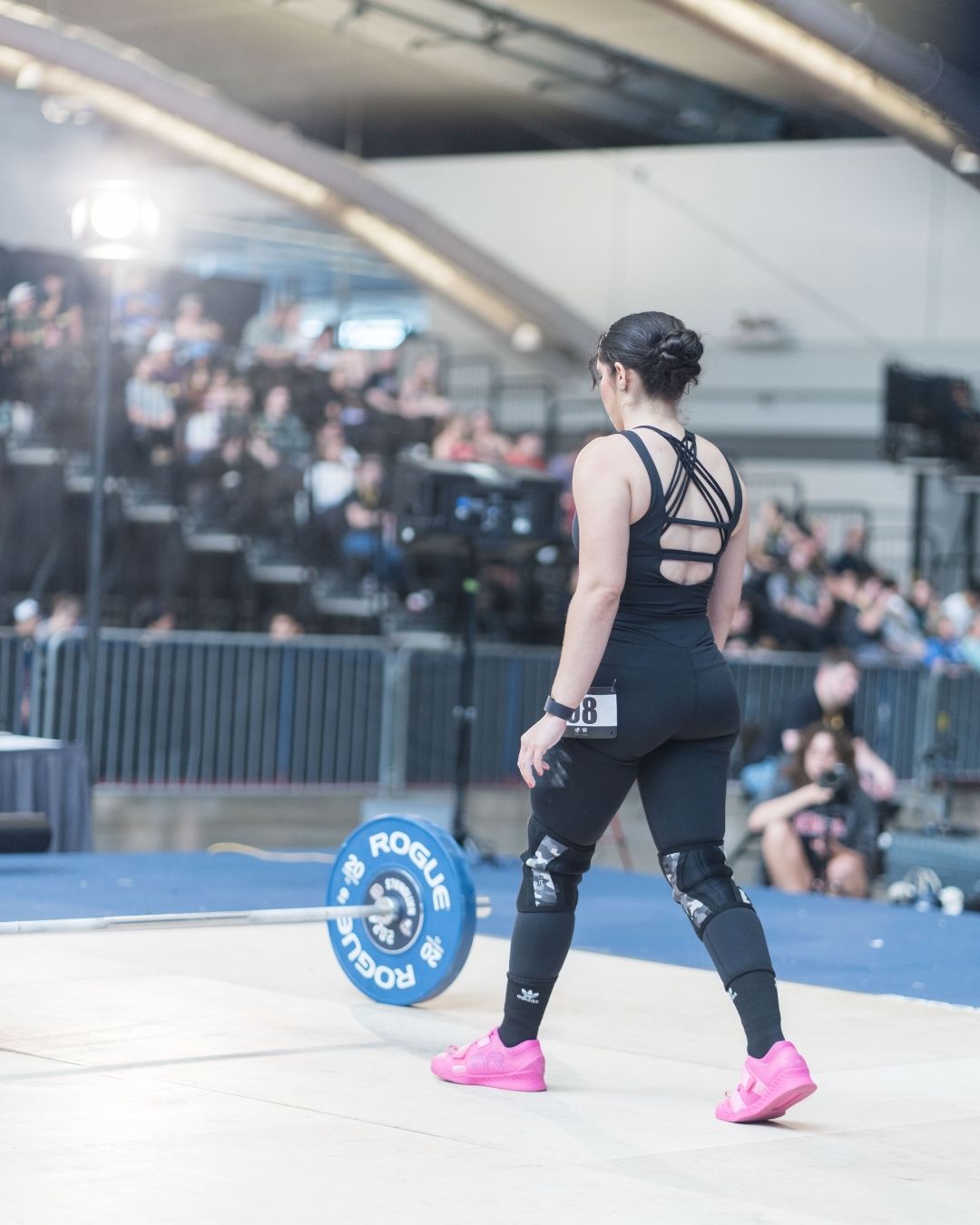 Coach Alanys walking torwards a bar on a weightlifting competition