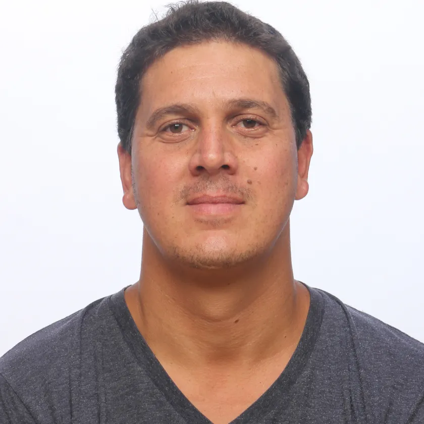 Middle-aged man in gray V-neck shirt, neutral facial expression
