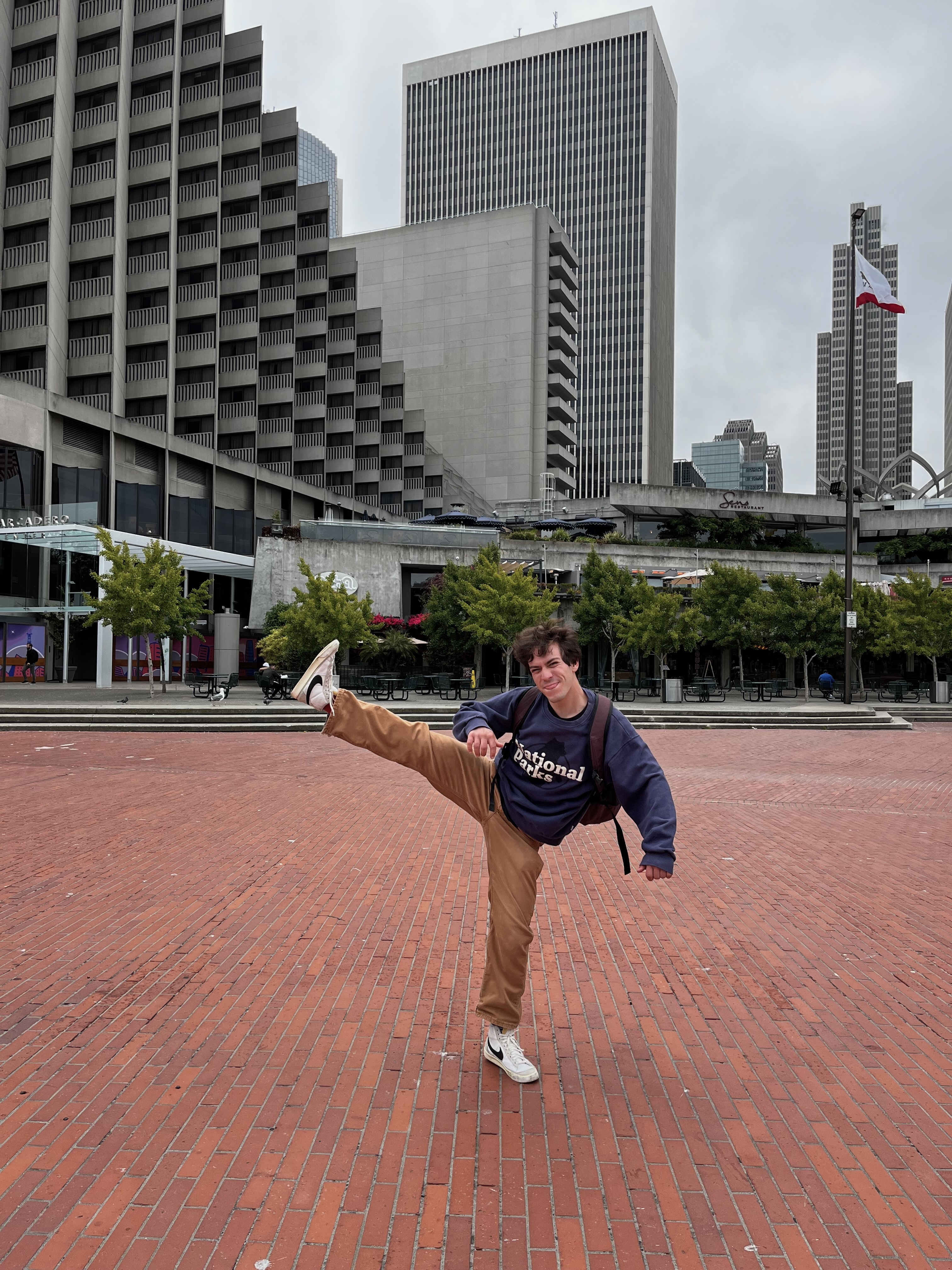 a picture of sam magid kicking the air by the Embarcadero in San Francisco