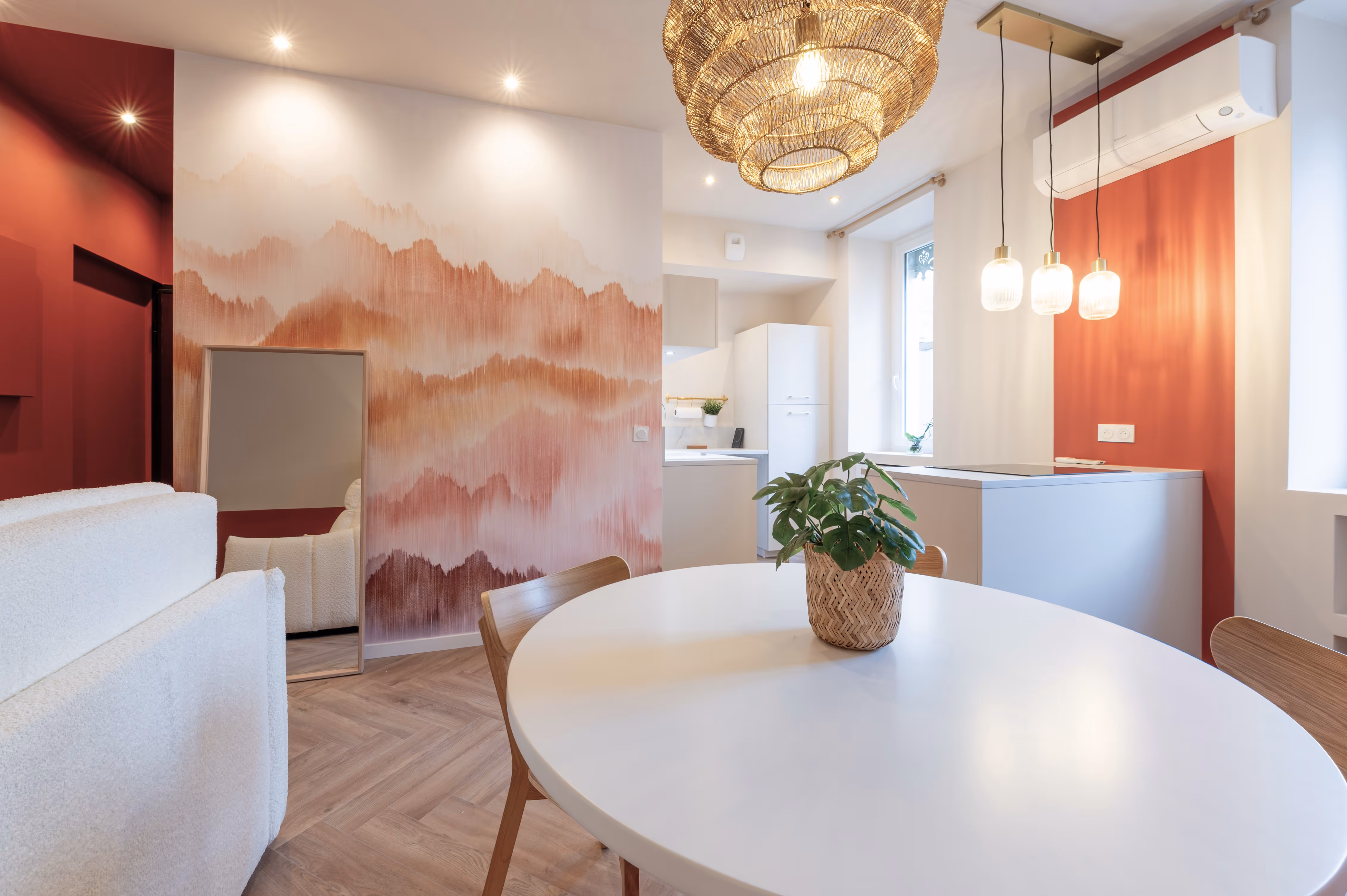 Salle à manger avec table ronde blanche, chaises en bois et mur rouge, projet Cocoon à Grenoble