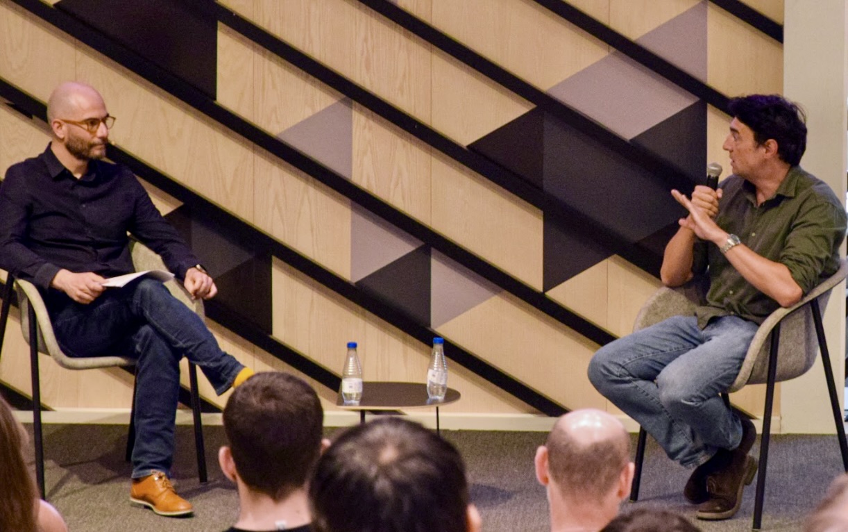People sitting listening to two people talking
