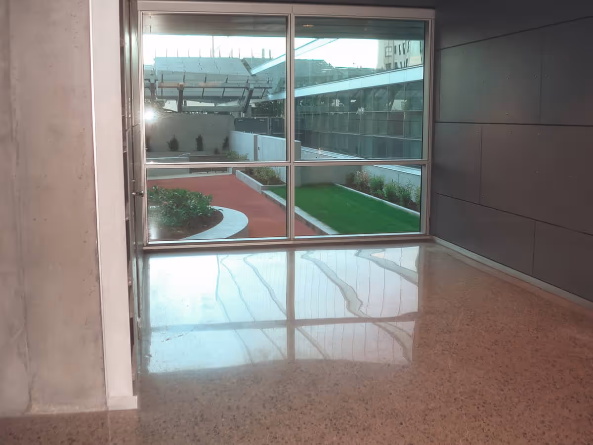 A view of concrete flooring with a view out of a window