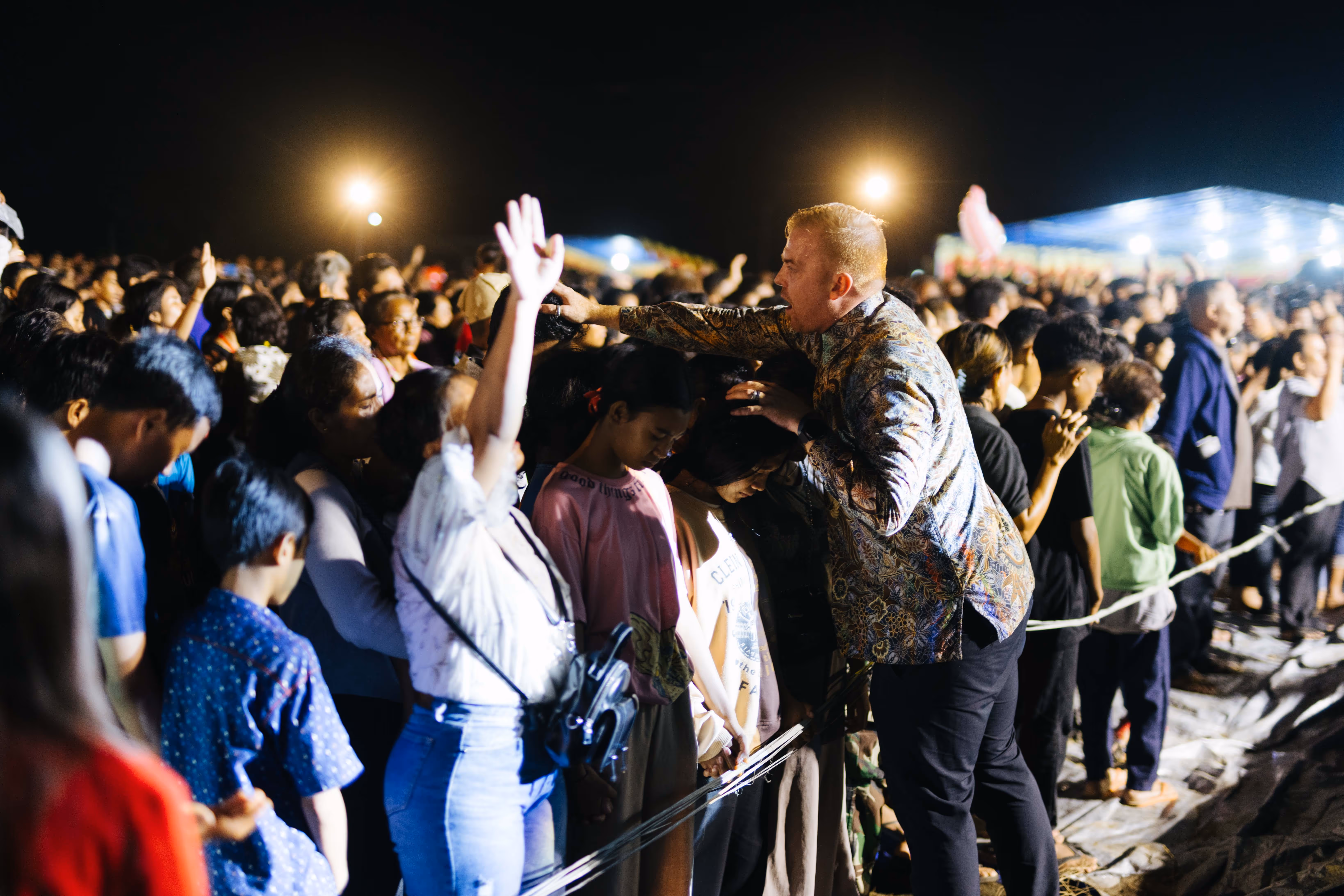 Andrew enthusiastically connects with the crowd, sharing his passion and energy as he engages with them at a lively gospel festival.