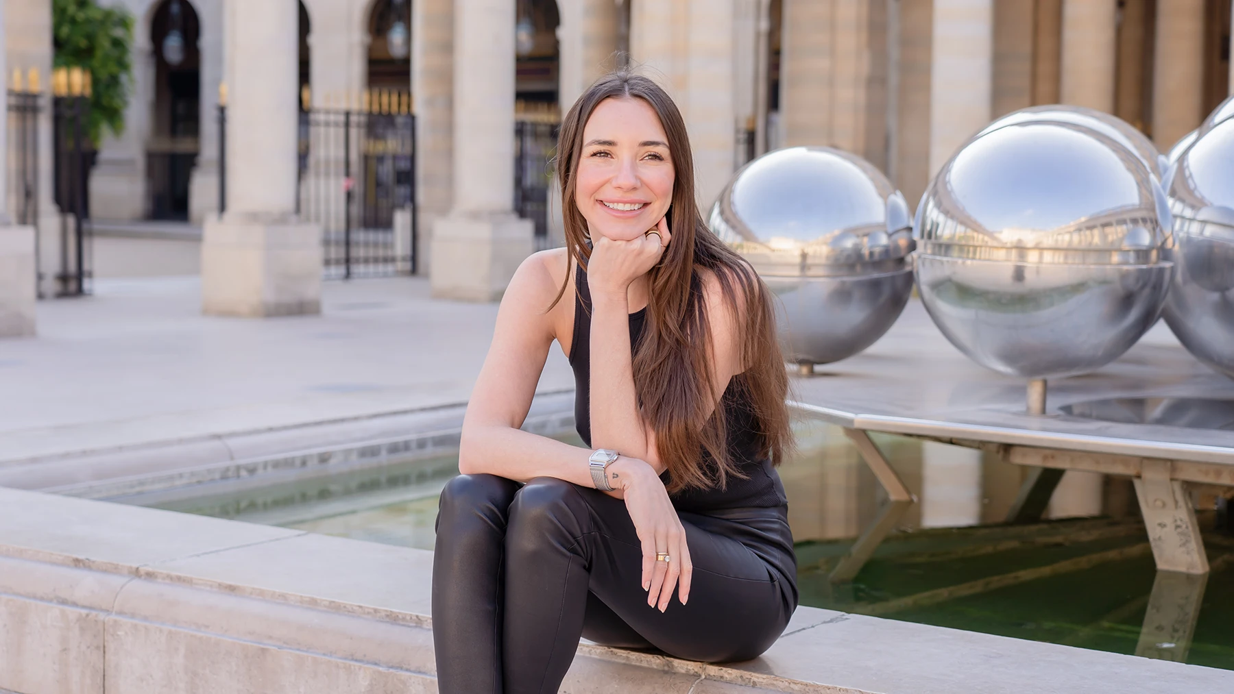 Photo of Blaine in black pants and a black tanktop sitting, smiling