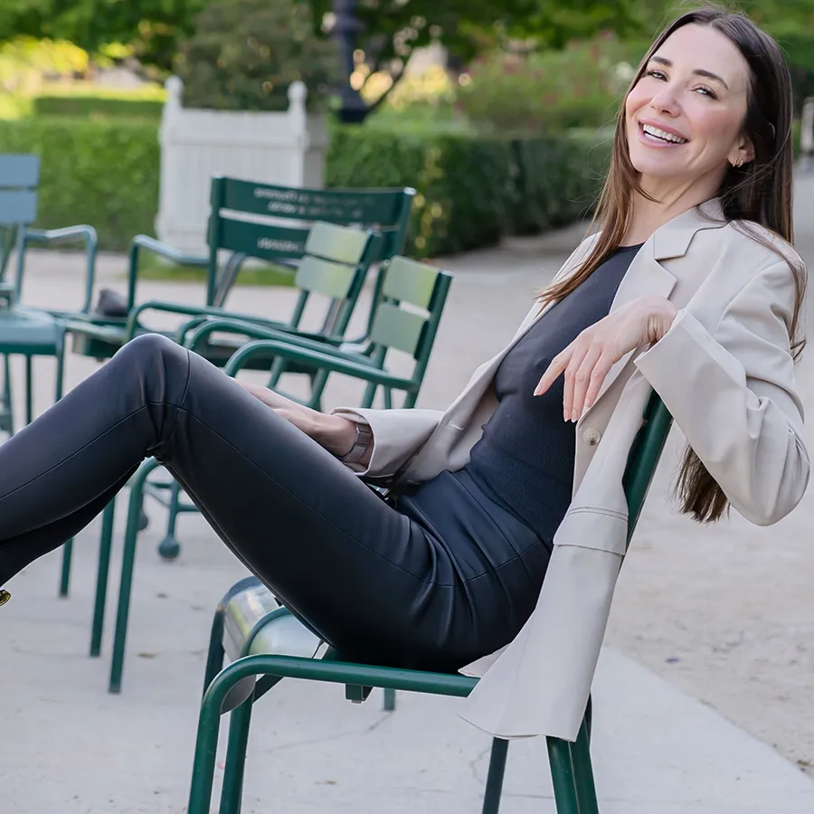 Blaine in a tan blazer, leaning back on a chair, smiling