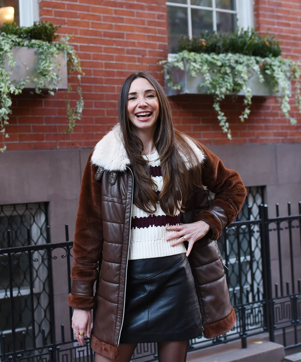 Blaine, in the West Village, wearing a puffy brown jacket, smiling