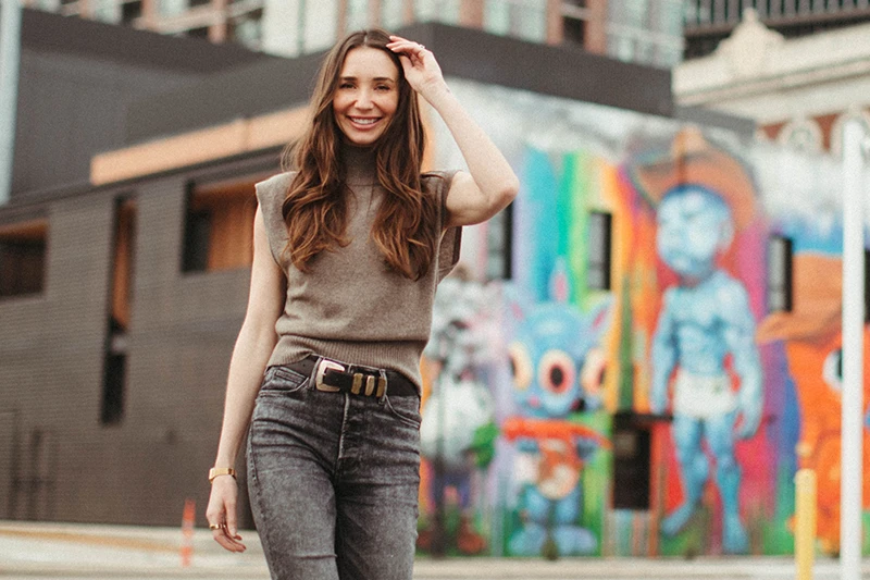 Blaine in a tan top, walking, smiling