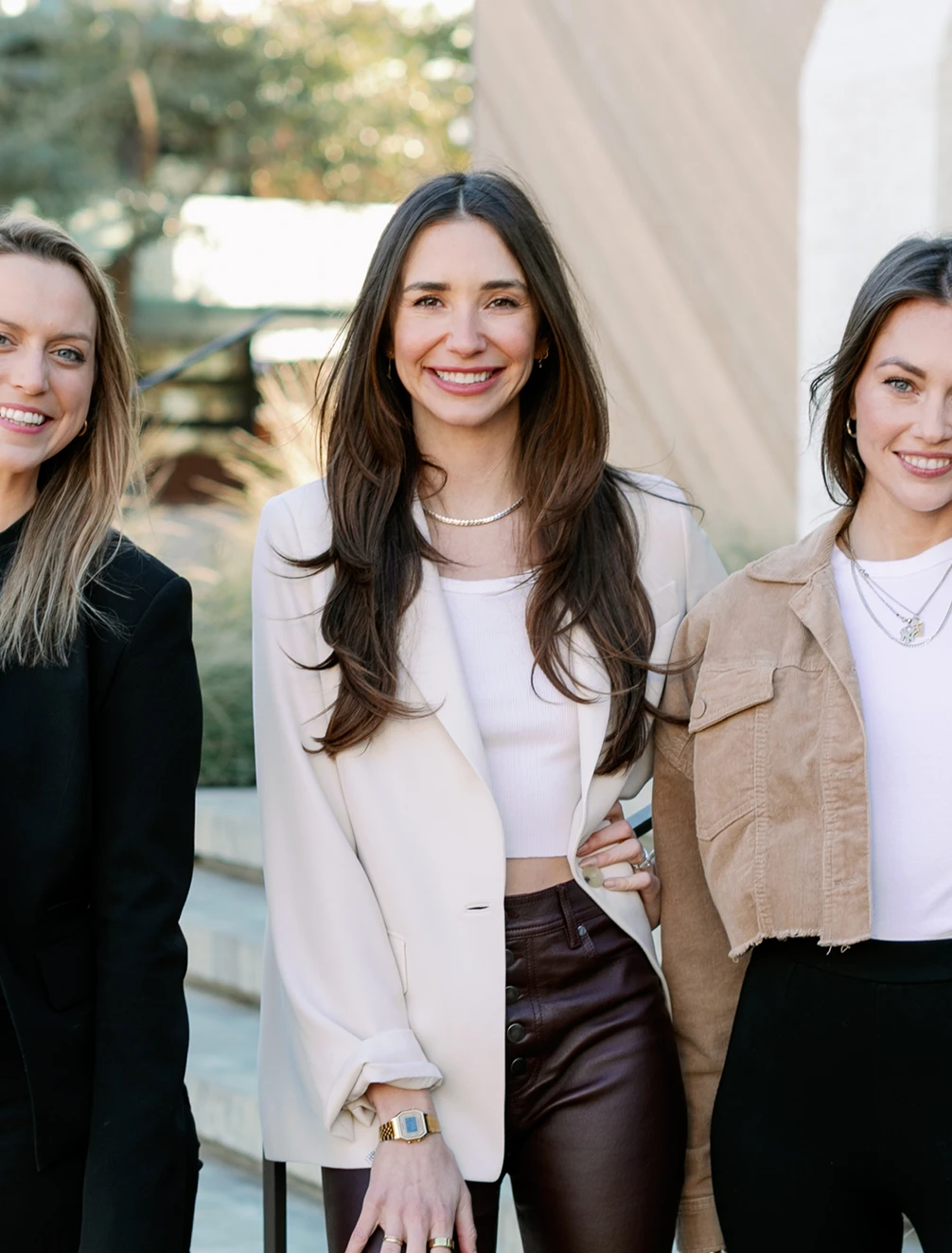 Blaine, smiling, holding a white cup seated at a red café table with croissants.