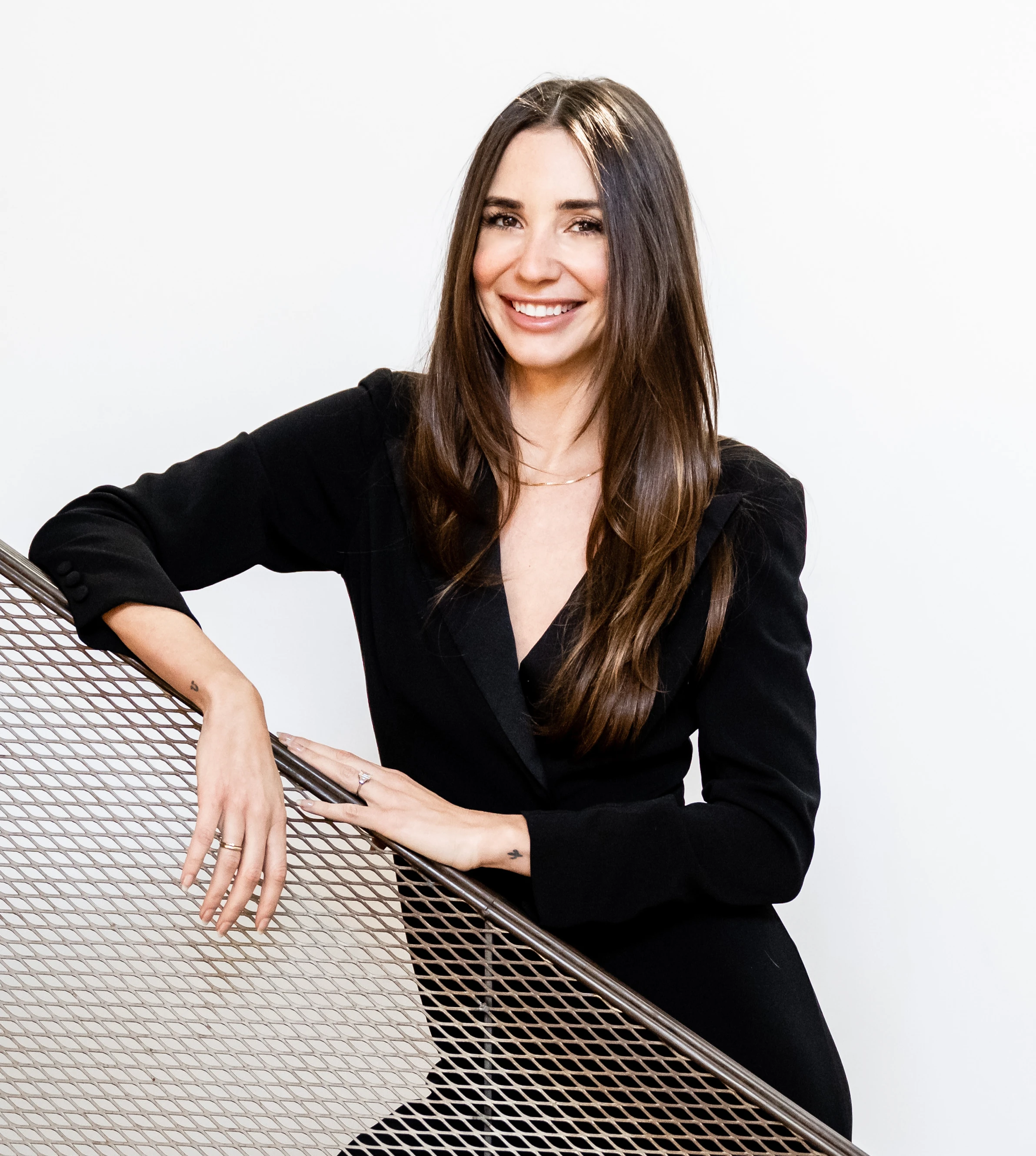 Photo of Blaine in a black dress on a staircase, smiling