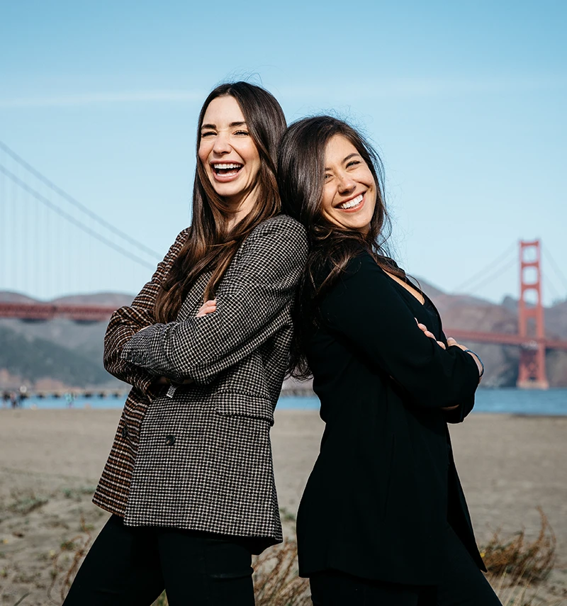 Photo of Blaine and her teammate Tara, smiling, in front of the Golden Gate Bridge