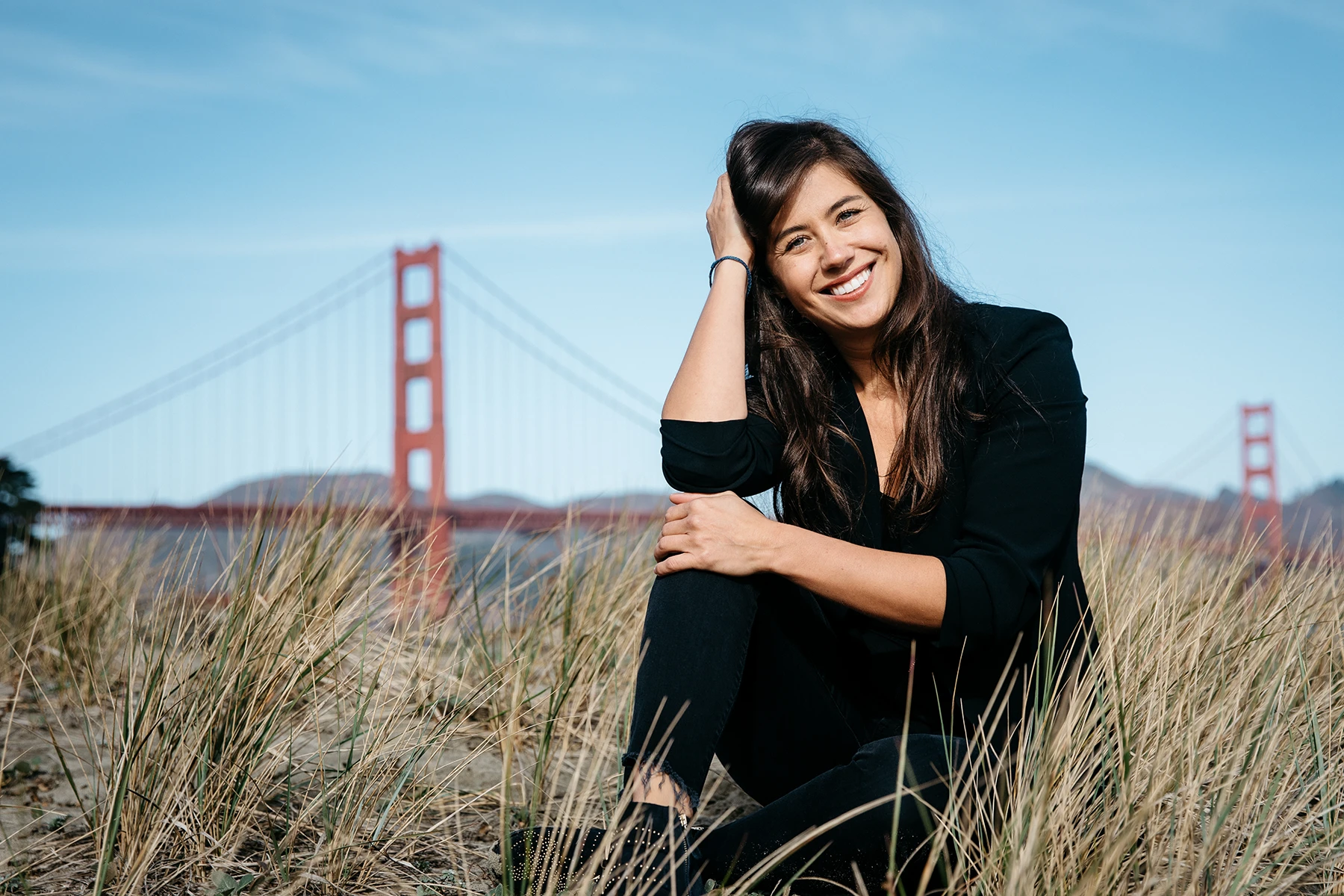 Photo of Tara, smiling, in front of the Golden Gate bridge