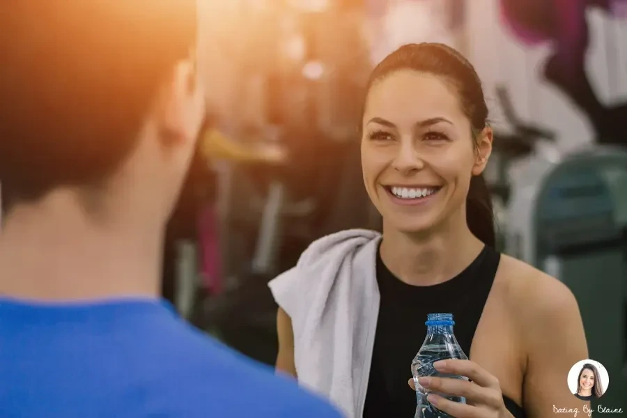 A girl with water bottle, smiling to a guy