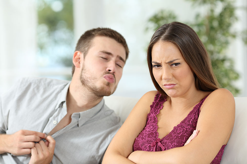 Man making kissing face, and woman frowning