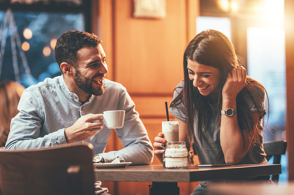 Man and woman at coffee, enjoying a laugh together