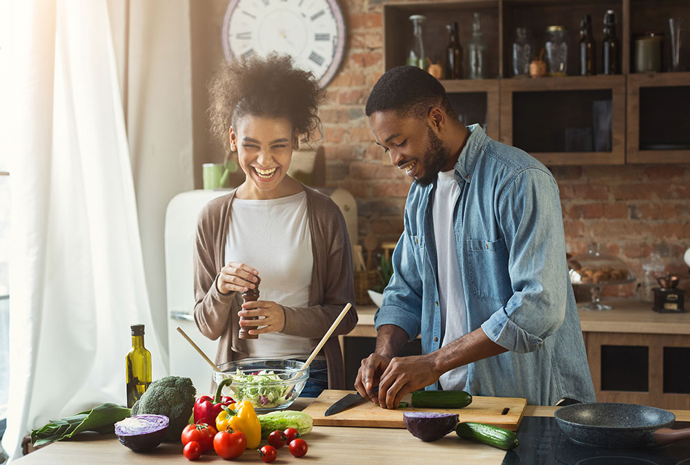Couple in a kitchen preparing ingredients for a meal