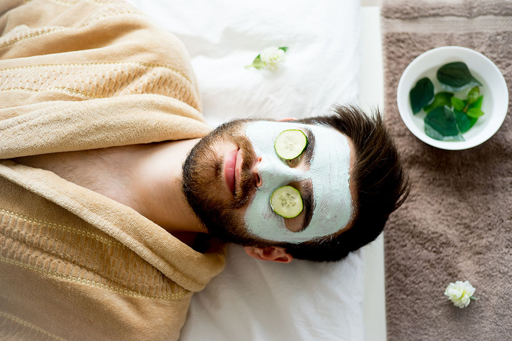 Man with cucumbers on his eyelids in a spa environment