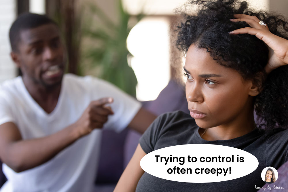 Woman seated on white couch looking upset, with man in background shouting and pointing finger at her