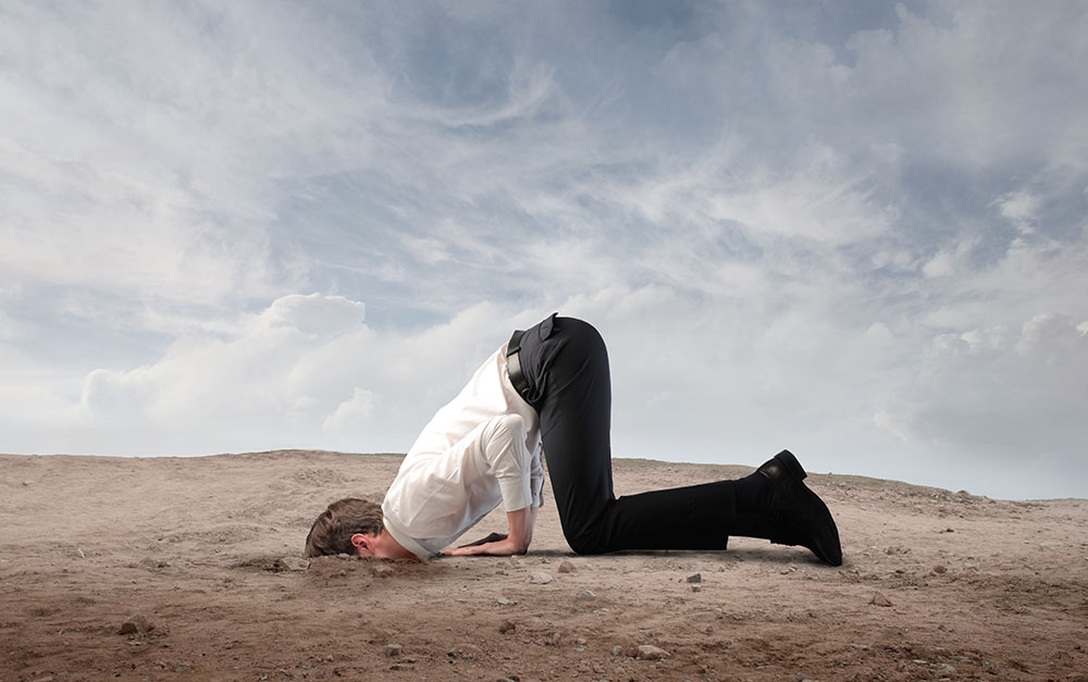 Photo of a man with his head buried in the ground