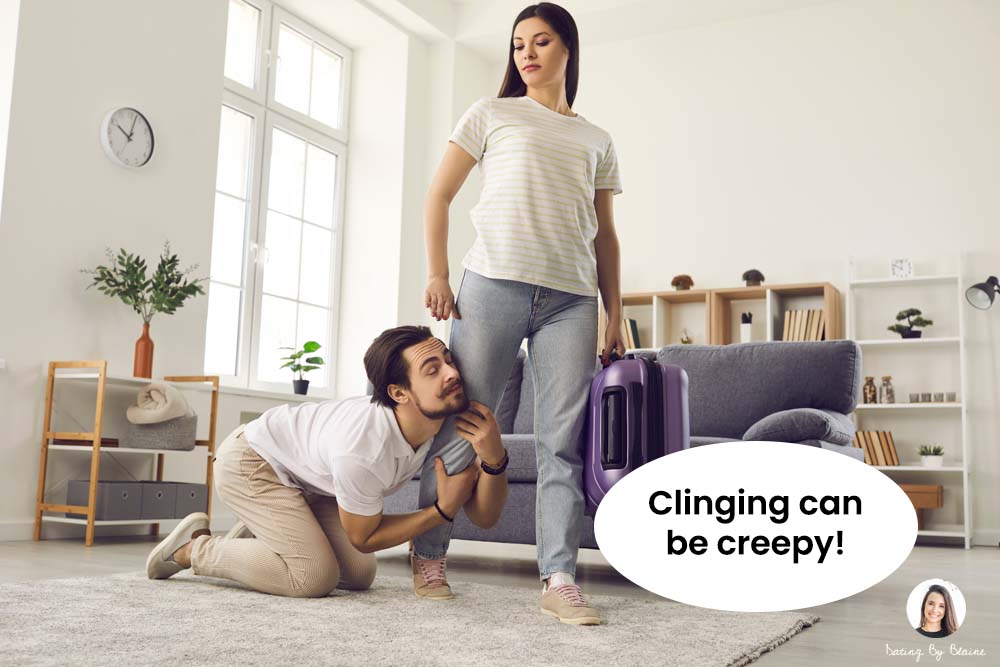 Man holding onto woman's leg in an apartment living room, with pained expression, while woman holding suitcase, presumably leaving, looks annoyed