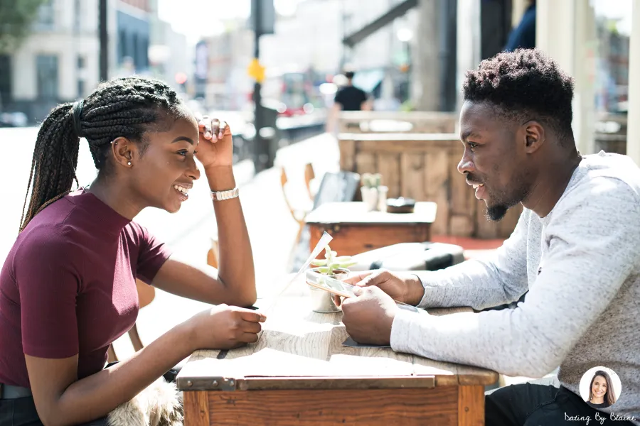 Man and woman talking over lunch at an outdoor table