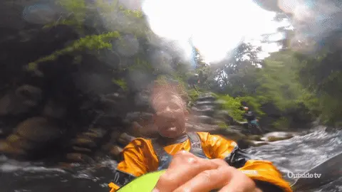 Man in a kayak in a scenic river giving a thumbs up