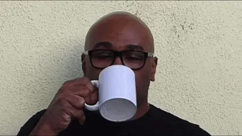 Gif of a man sipping, then spitting out, a liquid from a coffee mug