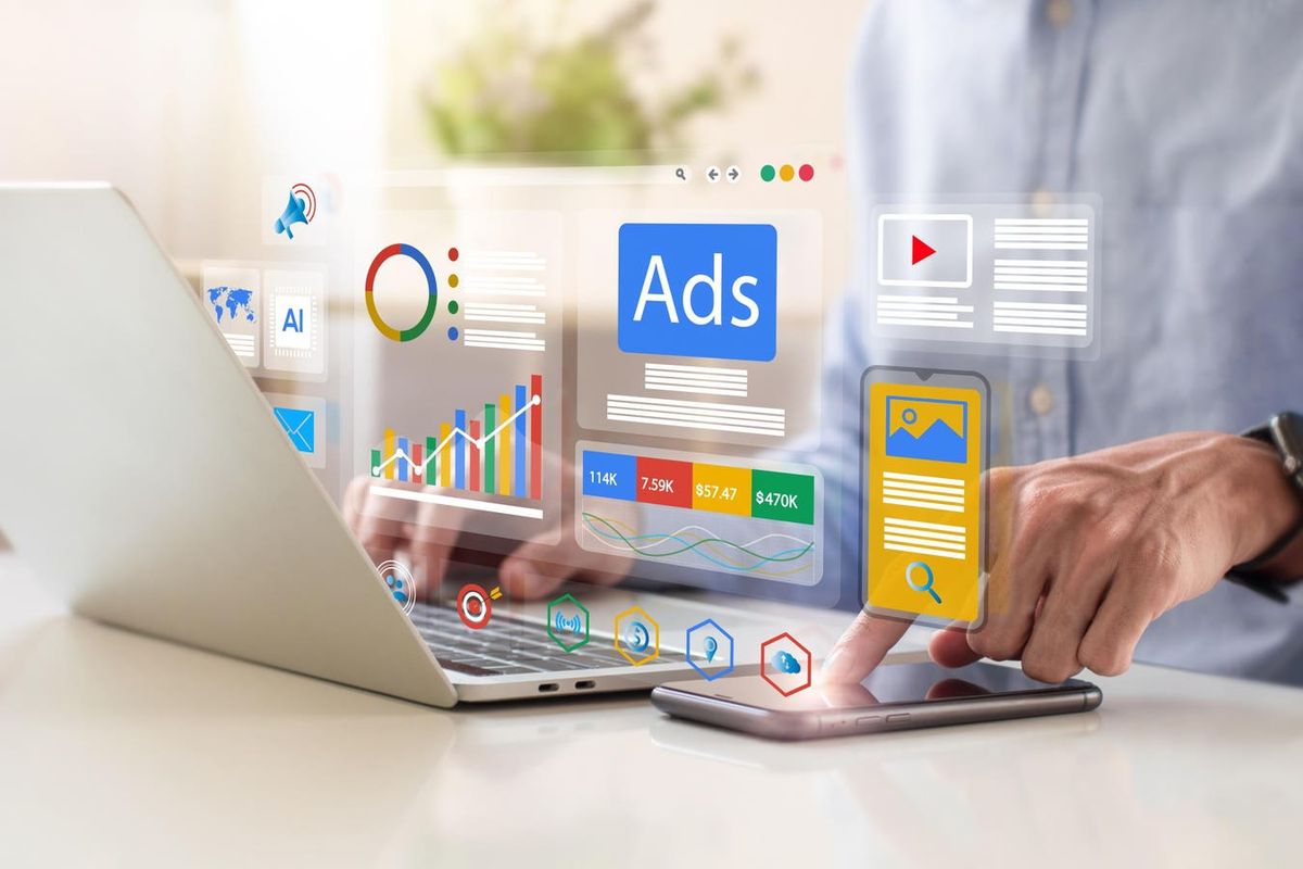 Man uses a laptop and smartphone with floating digital ads, charts, and marketing analytics icons overlaid.