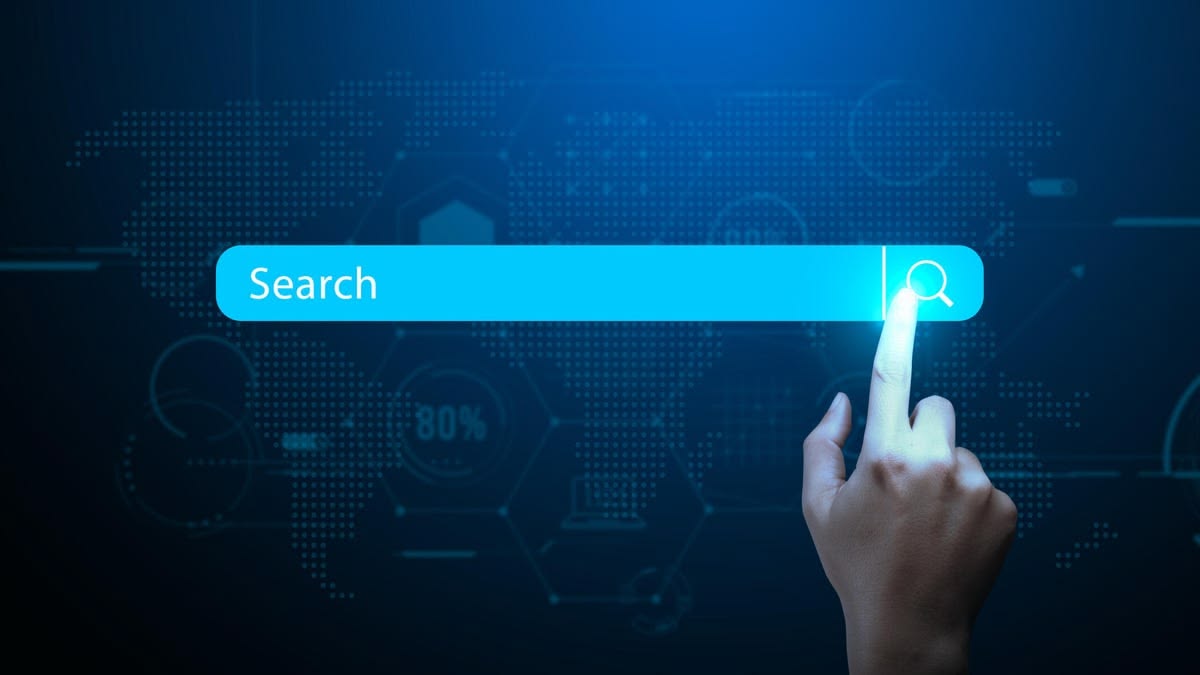 Hand tapping a glowing search bar over a world map, representing global talent search.