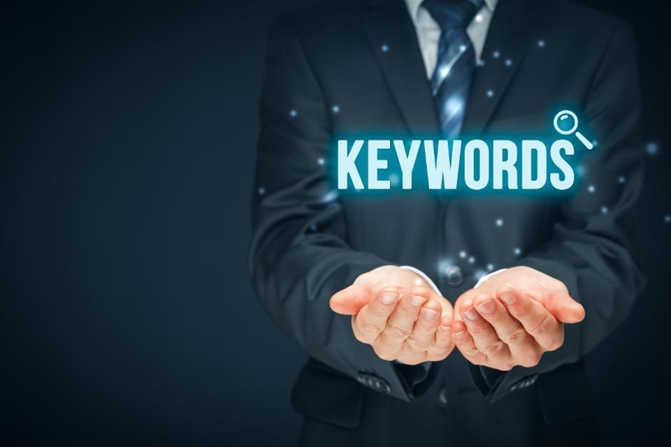 Recruiter holding a glowing "Keywords" search icon, representing keyword-based talent search.
