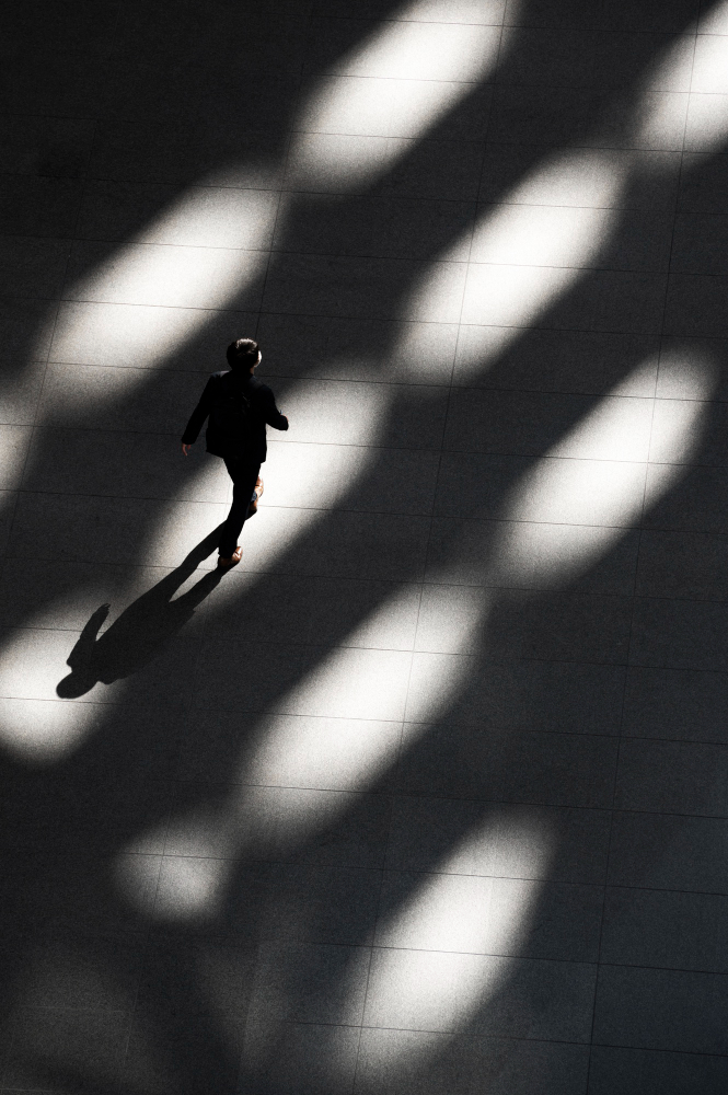 Birds eye view of a womaning walking in shadows