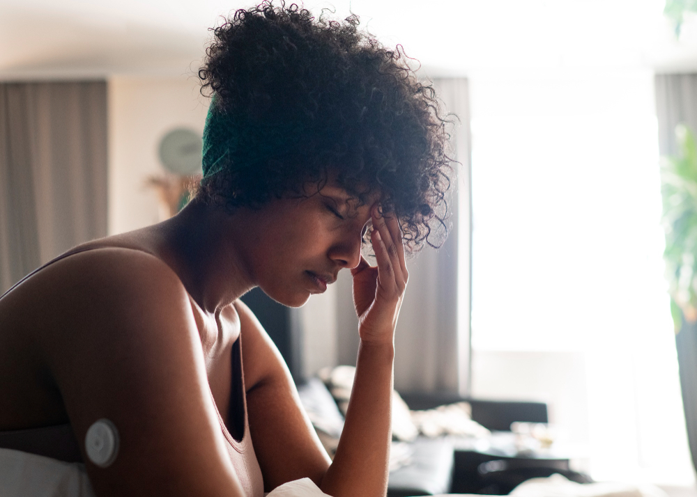 black woman sitting with her face in her hands, stressed out