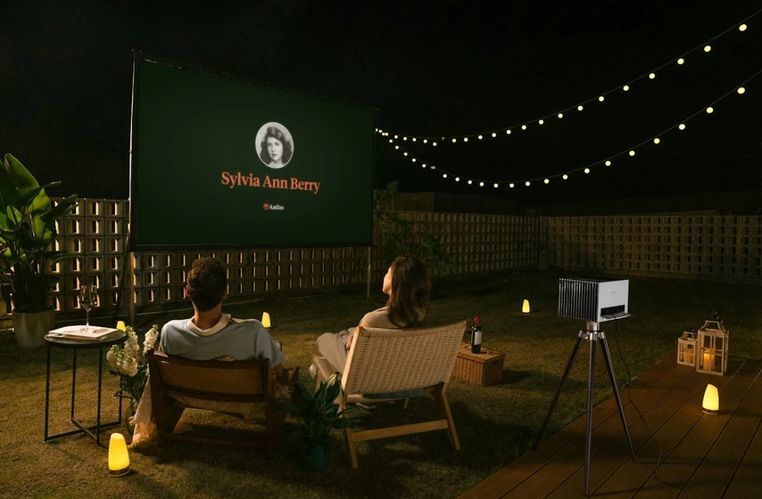 Friends in a backyard watching an Aatlas slideshow on an outdoor screen