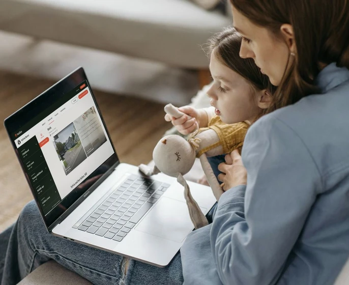 A mother and young daughter looking at an Aatlas timeline on a laptop