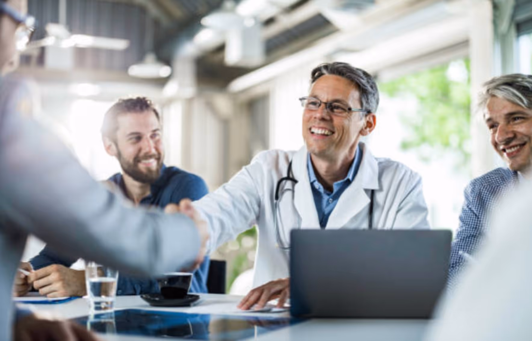 A candidate interviewing for a position at the hospital shaking hands with the hospital's hiring manager 
