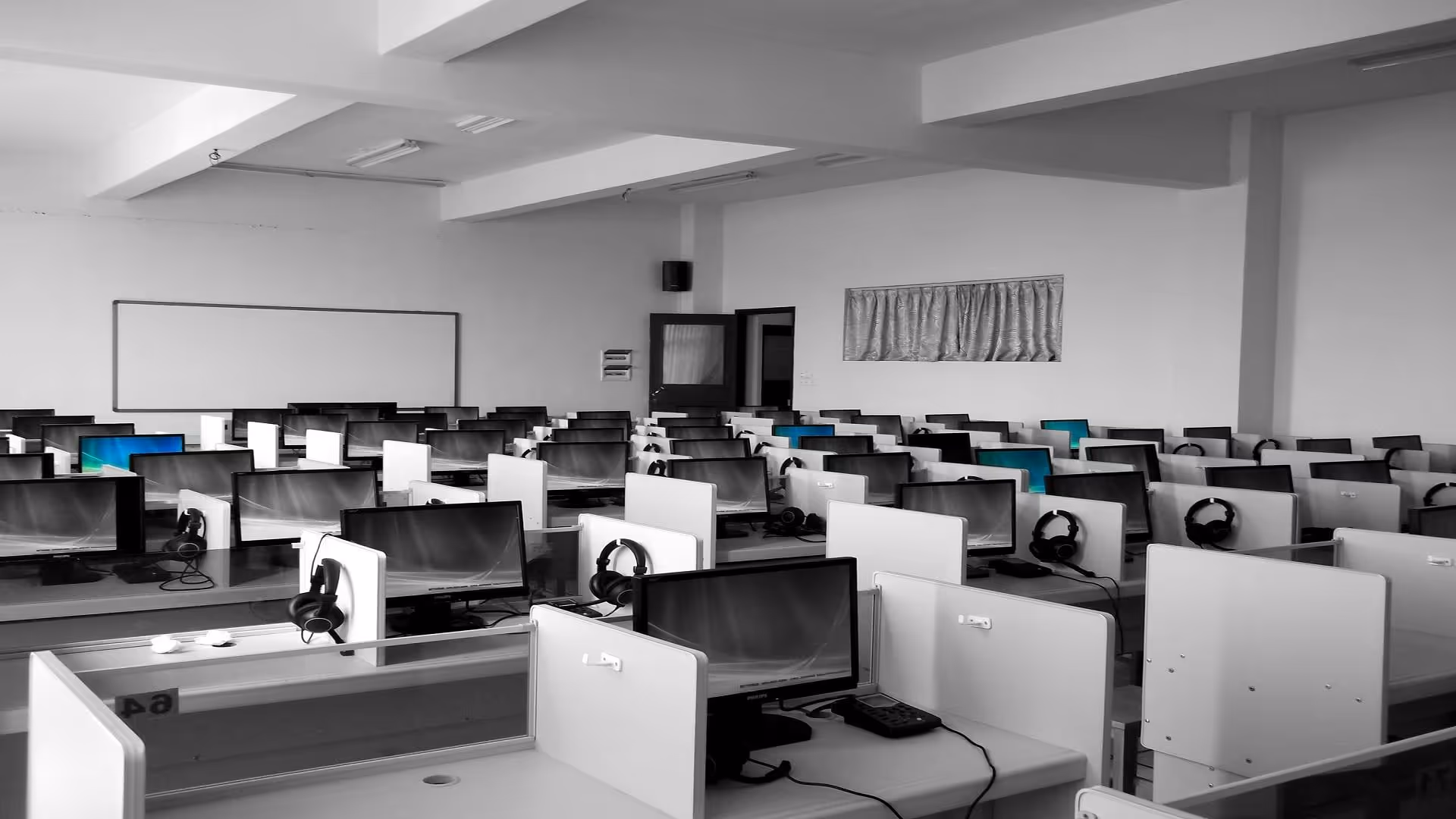 Empty office with rows of workstations, symbolizing employee turnover in offshore outsourcing.