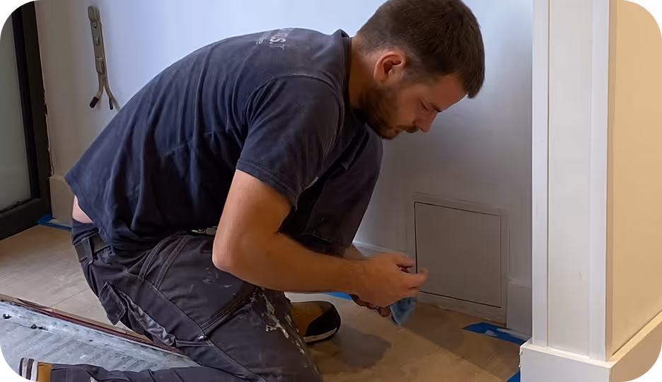 un employé max et vous à genoux en train de travailler sur le coin d'un mur