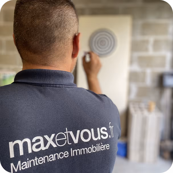 un employé max et vous de dos avec le tshirt qui a le logo max et vous, et qui joue au fléchettes