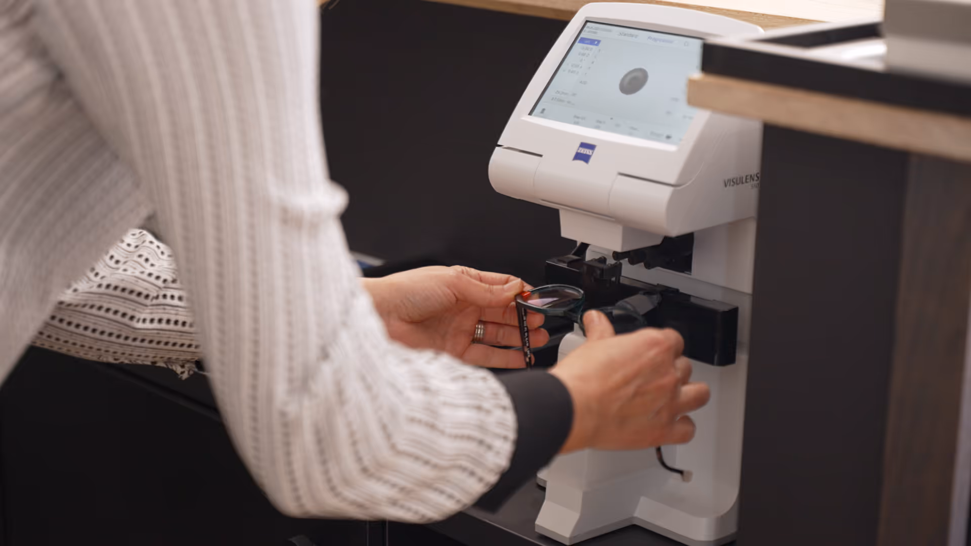 Person using Zeiss Visulens machine for eye measurement or lens fitting