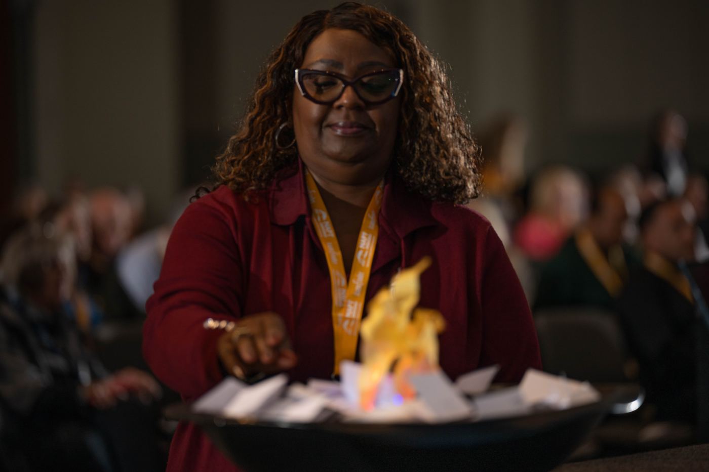 An educator placing her fear card in the fire pit