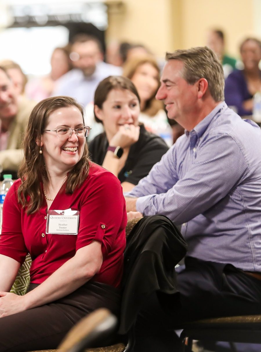 Educators laughing together at their table during a keynote