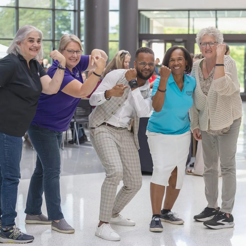 Educators laughing and striking a pose with Darryl