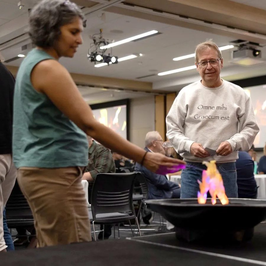 Faculty and staff putting their fear cards into the fire pit