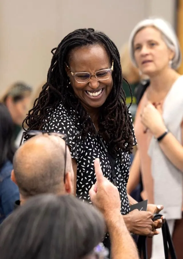 A staff member laughs with colleagues during the keynote